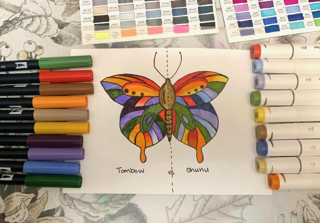 colorful butterfly drawn on paper surrounded by alcohol markers