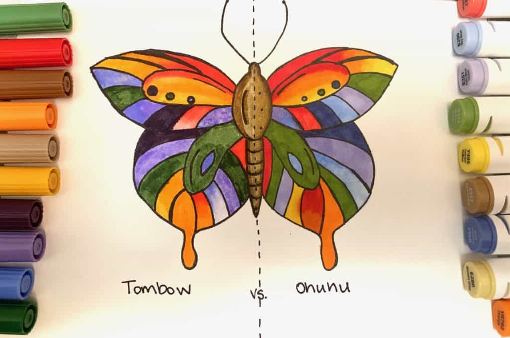 colorful butterfly drawn in markers on paper, surrounded by markers